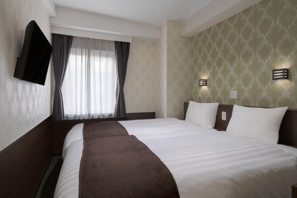 Postel nebo postele na pokoji v ubytování Hotel Centmain Nagoya