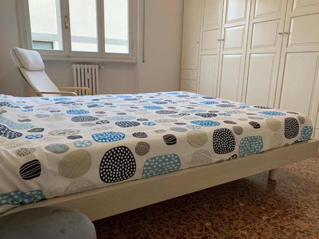 ein Bett mit einer blauen und weißen Bettdecke und einem Stuhl in der Unterkunft Venere Apartment in Florenz