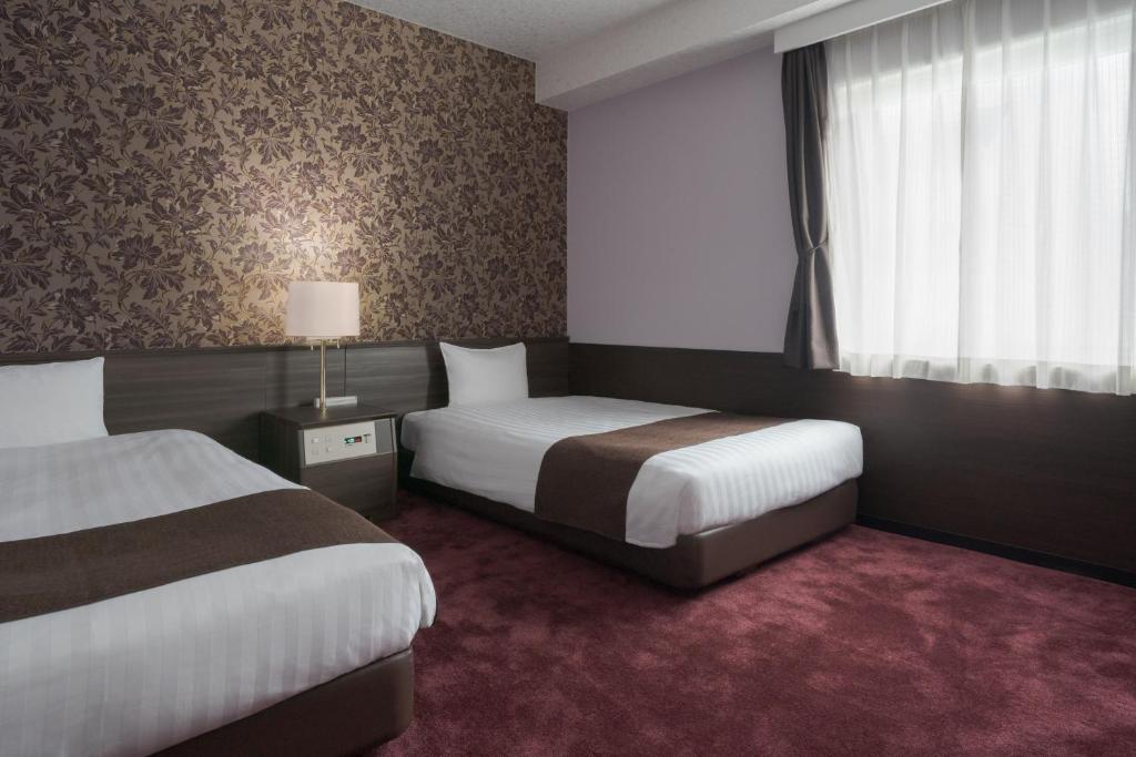Postel nebo postele na pokoji v ubytování Hotel Centmain Nagoya