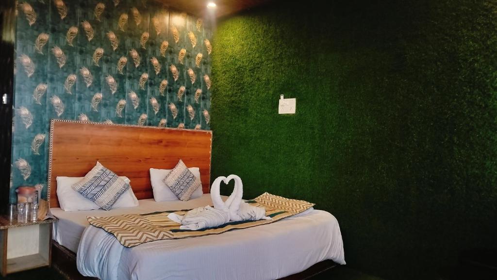 達蘭薩拉的住宿－Hotel Nirbana Heights，一间卧室设有两张床和绿色的墙壁