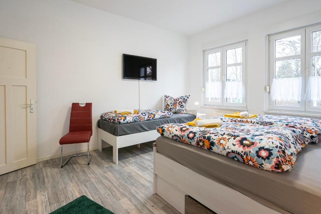 1 Schlafzimmer mit 2 Betten und einem Stuhl in der Unterkunft Appartement am Westerntor III in Wernigerode