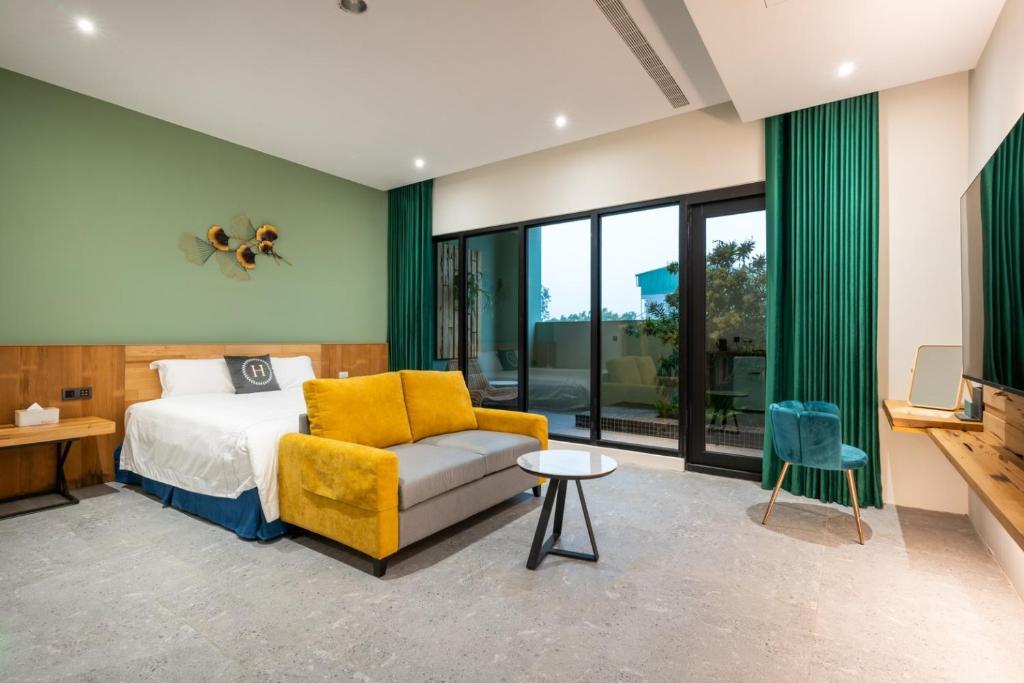 - une chambre avec un lit et une chaise jaune dans l'établissement 禾楓覓月文旅, à Minxiong
