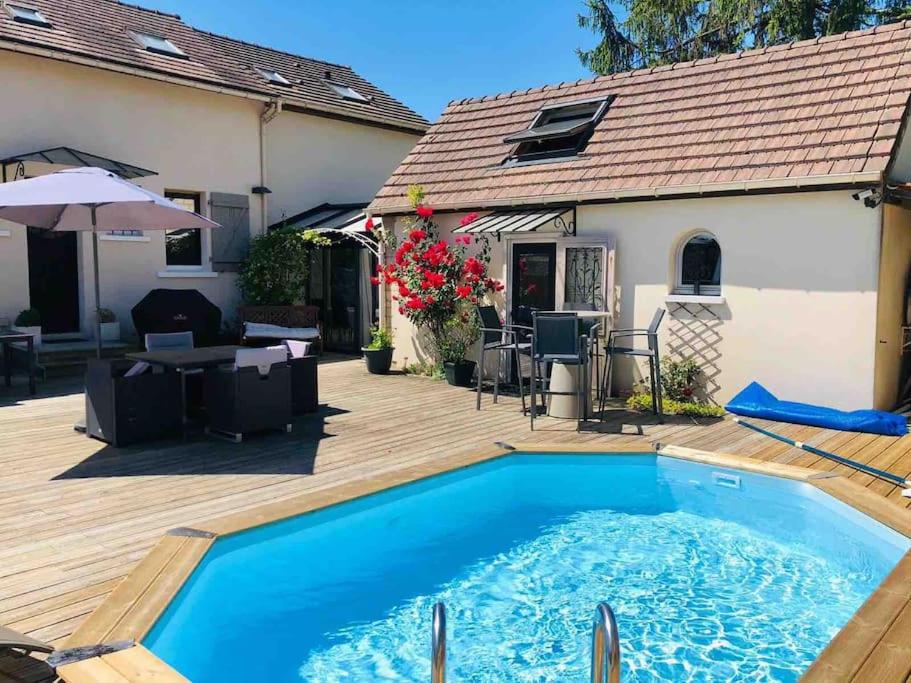 DampmartにあるGuest House proche Disneyland Paris Réouverture Piscine fin avrilの家の裏庭にあるプール