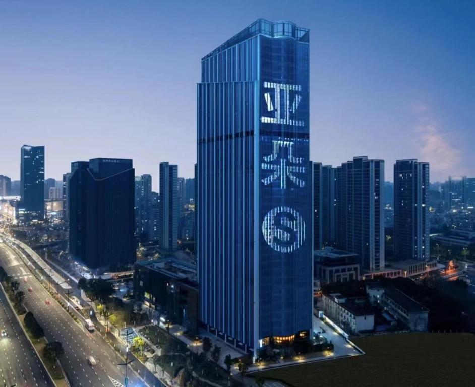 a tall building with a sign on it in a city at Atour S Hotel Hangzhou Binjiang Changhe Jiangnan Avenue in Hangzhou
