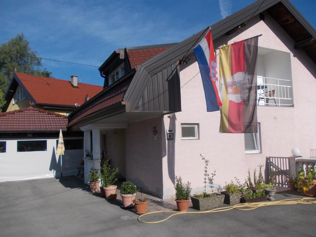 a house with two flags on the side of it at Panorama Apartman in Molvice