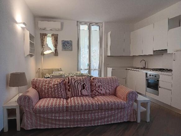 ein Wohnzimmer mit einem Sofa und einer Küche in der Unterkunft angolo della quiete citr 011017 cav 0044 in Levanto