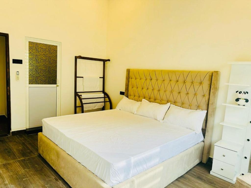 um quarto com uma grande cama branca e uma cabeceira dourada em Senu Resort Katunayaka em Katunayaka
