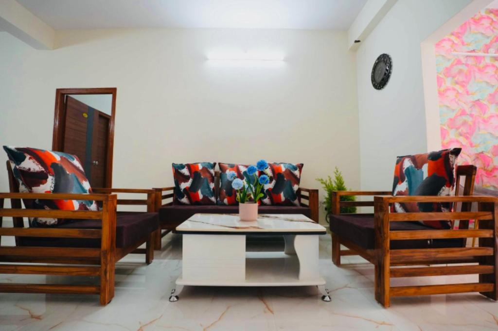 a living room with two chairs and a table at Yellow Bells Serviced Apartments Hitech City in Hyderabad