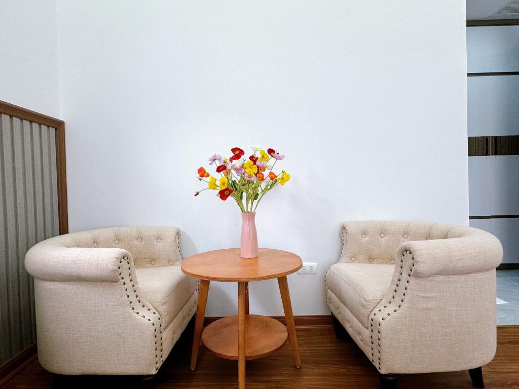 下龍灣的住宿－Phượng Hoàng villa，两把椅子和一张带花瓶的桌子