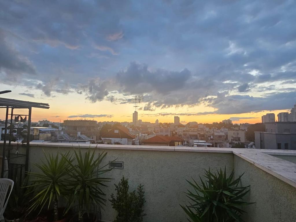 a view of a city at sunset from a balcony at Skyview Retreat Romantic Retreat Views 360 Rooftop in Tel Aviv