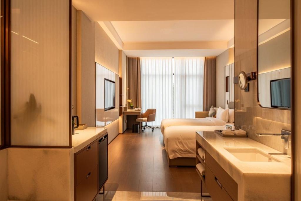 a large hotel room with a bed and a bathroom at Guus Hotel in Zengcheng