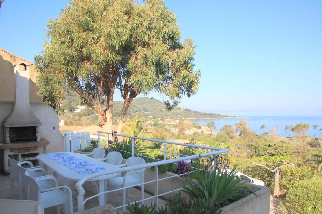 d'un balcon avec une table, des chaises et un arbre. dans l'établissement La villa Acacia, à Coti-Chiavari