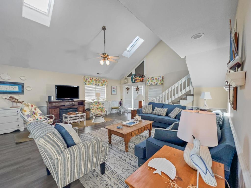 ein Wohnzimmer mit blauen Sofas und einem Tisch in der Unterkunft Lazy Days In Cherry Grove! in Myrtle Beach