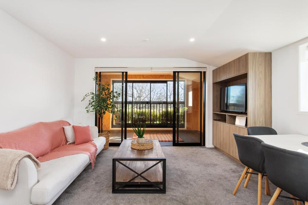 a living room with a couch and a table at Penthouse Apartment Scenic Views-Spacious 2br in Christchurch