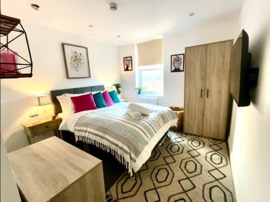 a bedroom with a bed and a wooden cabinet at Deluxe Ensuite Central Cov in Coventry