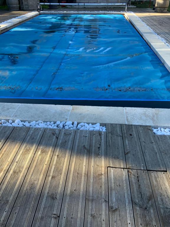 une piscine d'eau bleue et une terrasse en bois dans l'établissement Studio 1 à 2personnes, à Nîmes