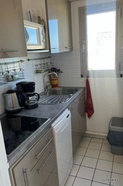 une petite cuisine avec un évier et une fenêtre dans l'établissement Appartement T2 vue Mer, moderne, clim 3 etoiles Parking 4PLMER53, à Canet