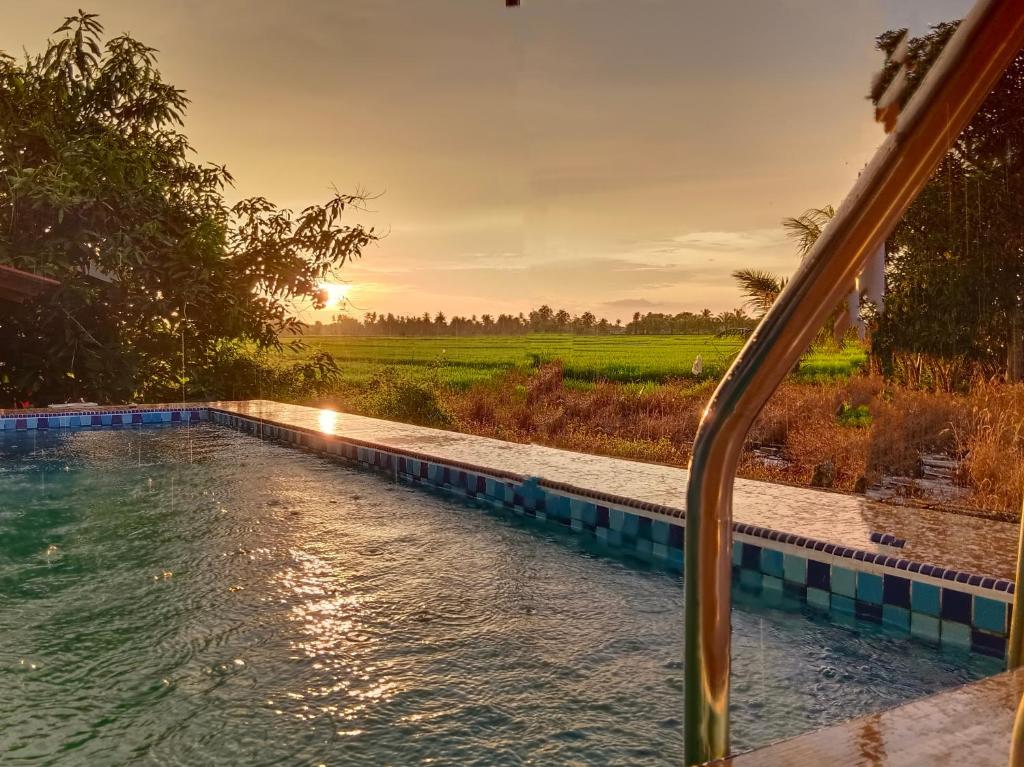 a view of a pool from a train window at Kurau Inn Farmstay in Kuala Kurau