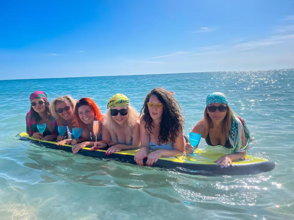 grupa kobiet leżących na desce surfingowej w wodzie w obiekcie Casa CalaMar w mieście Carrer del Mar