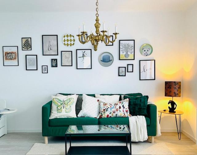 a living room with a green couch and pictures on the wall at Allegra Appartements in Nohfelden