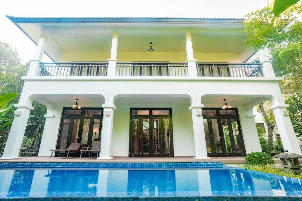 a house with a swimming pool in front of it at 3BR garden pool villas in beach resort in Da Nang