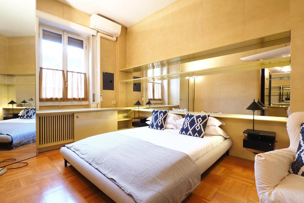a bedroom with a bed and a couch and a window at HomNest I S.Ambrogio Elegant Apt in Milan