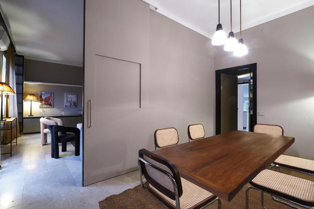 a dining room with a wooden table and chairs at HomNest I S.Ambrogio Elegant Apt in Milan