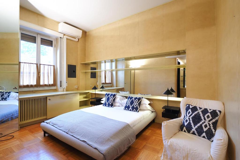 a bedroom with a bed and a couch and a chair at HomNest I S.Ambrogio Elegant Apt in Milan