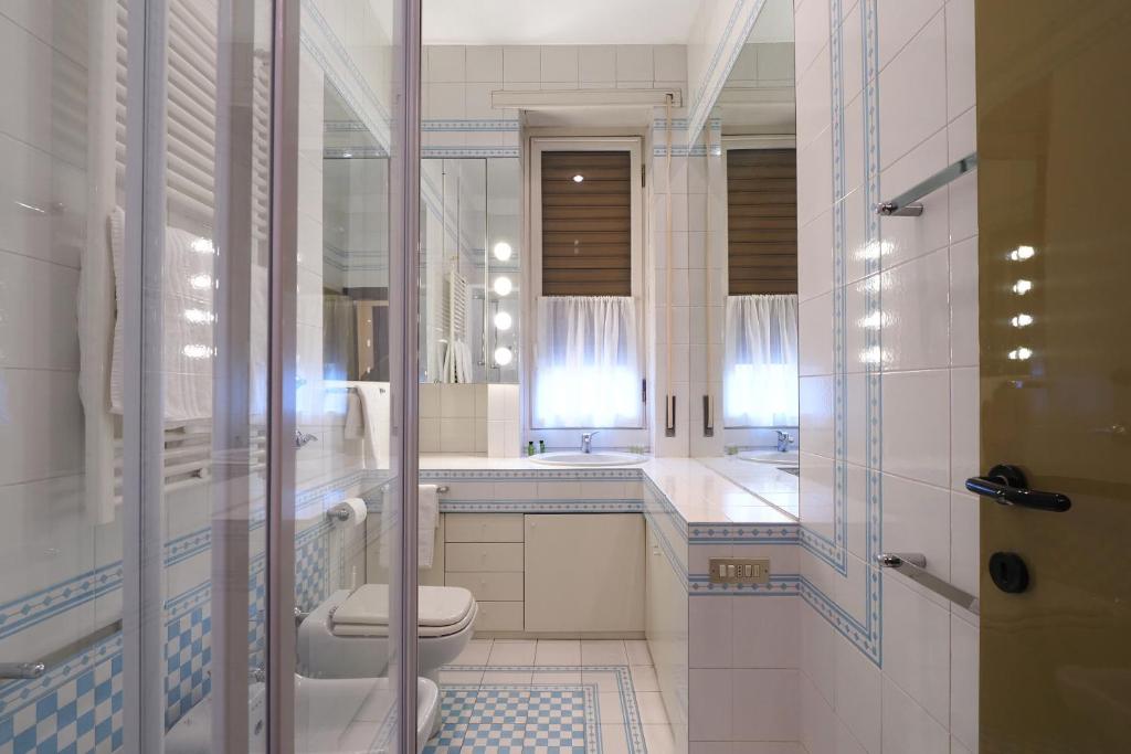 a white bathroom with a toilet and a sink at HomNest I S.Ambrogio Elegant Apt in Milan