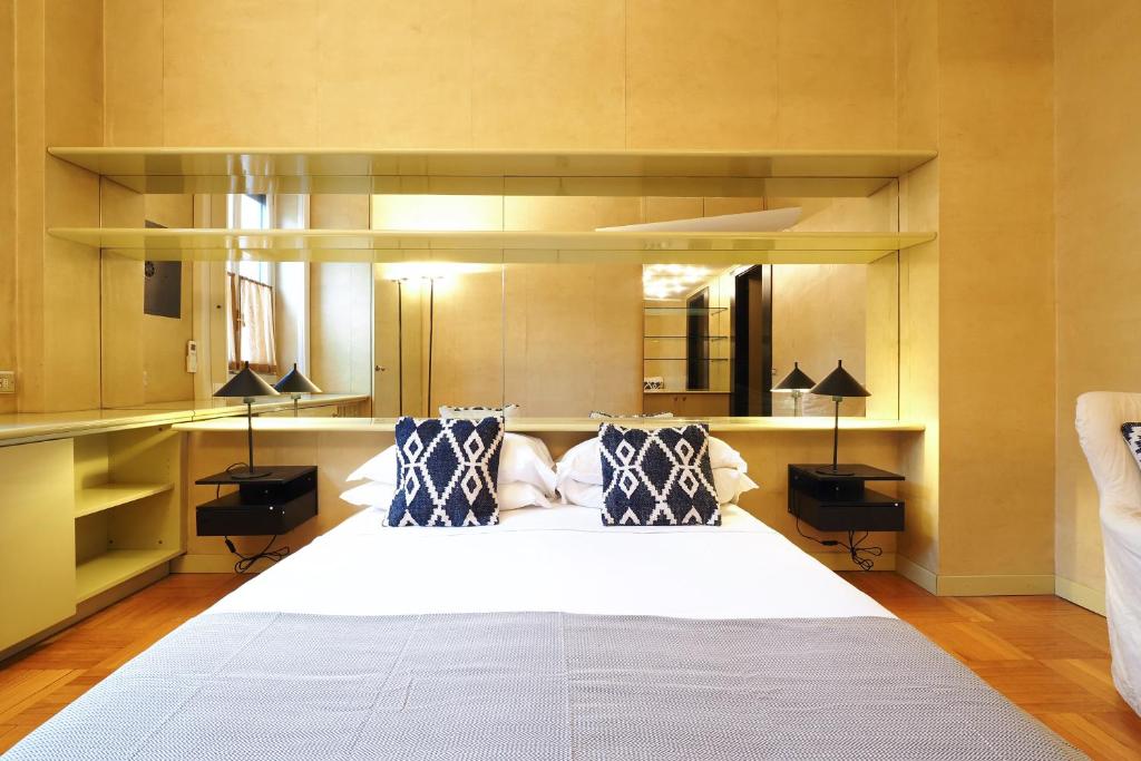 a bedroom with a large white bed with blue pillows at HomNest I S.Ambrogio Elegant Apt in Milan