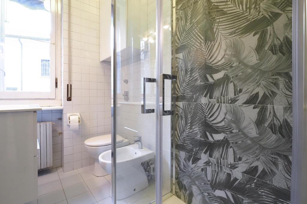 a bathroom with a toilet and a glass shower at HomNest I S.Ambrogio Elegant Apt in Milan