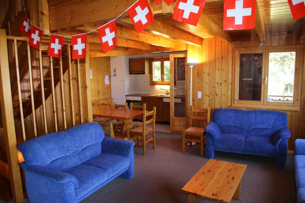 a living room with two blue couches and red and white crosses at Fontannets COSY & MOUNTAIN chalets in Veysonnaz