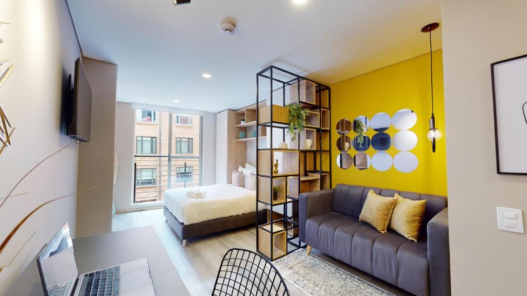 uma sala de estar com um sofá e uma cama em Exclusivos Aptos amoblados en el edificio Cabrera 85-12 em Bogotá