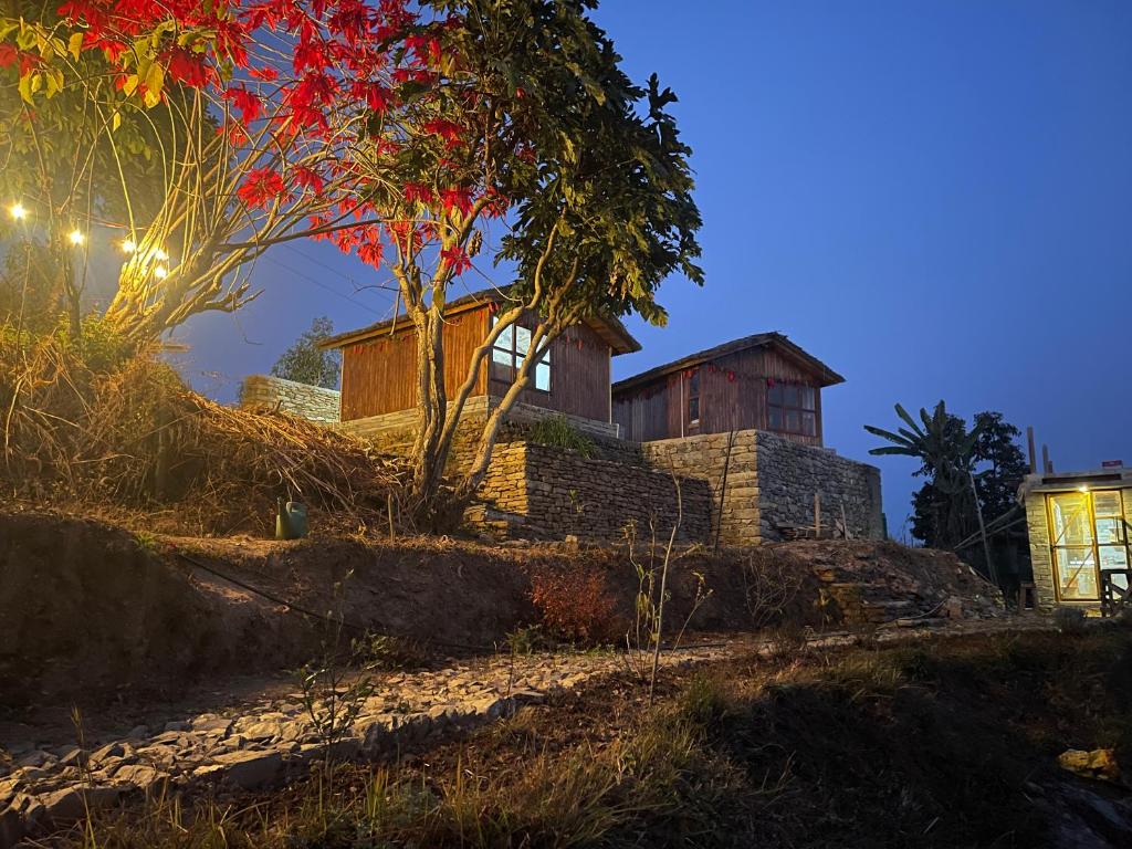 une maison au sommet d'une colline la nuit dans l'établissement HarroBarro Farms, à Lamjung