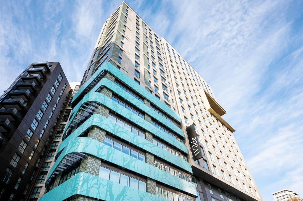 um edifício alto com um céu azul ao fundo em Wilde Aparthotels London Paddington em Londres