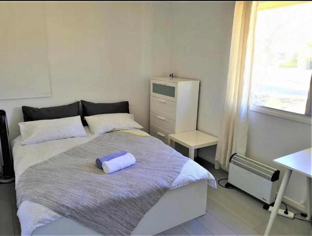 坎培拉的住宿－Private Room in a Shared House-Close to City & ANU-4，一间卧室配有一张床、一张书桌和一个窗户。