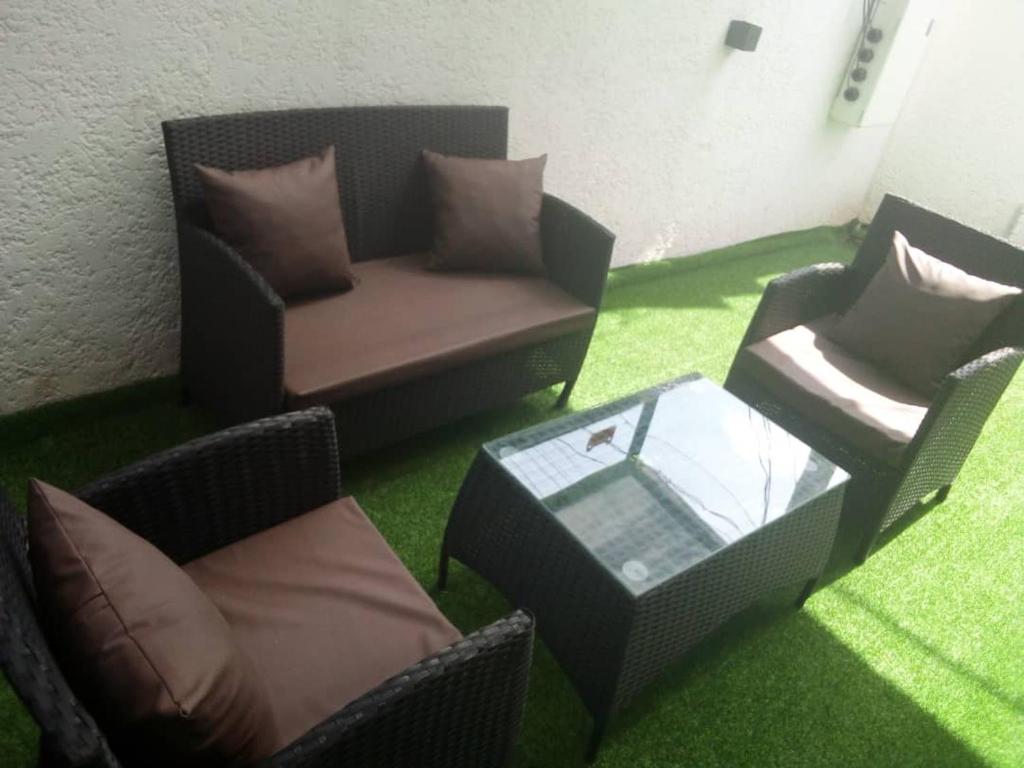 a living room with chairs and a table and a couch at House 32 in Enugu