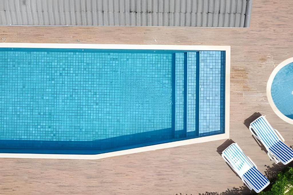 a swimming pool with two chairs next to it at bwelcome - pé na areia com piscina GH in Bertioga