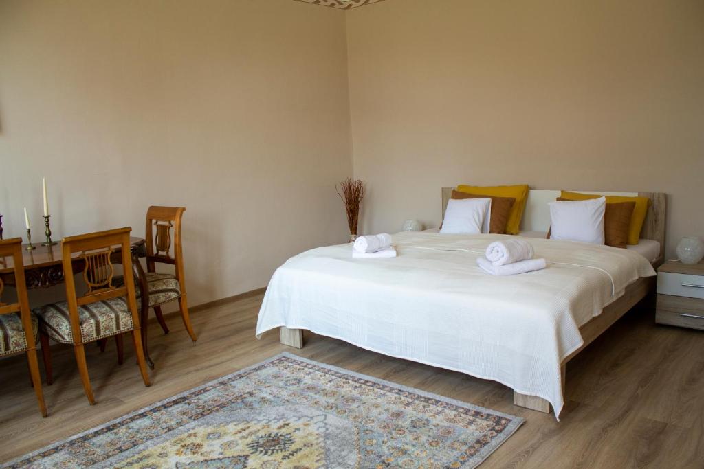 a bedroom with a large white bed with towels on it at Villa Flora in Kiskunmajsa