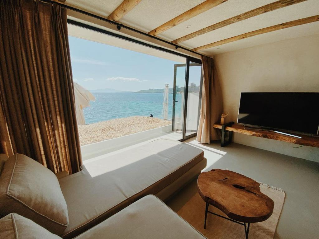 sala de estar con ventana grande con vistas a la playa en Townhouse en Bodrum