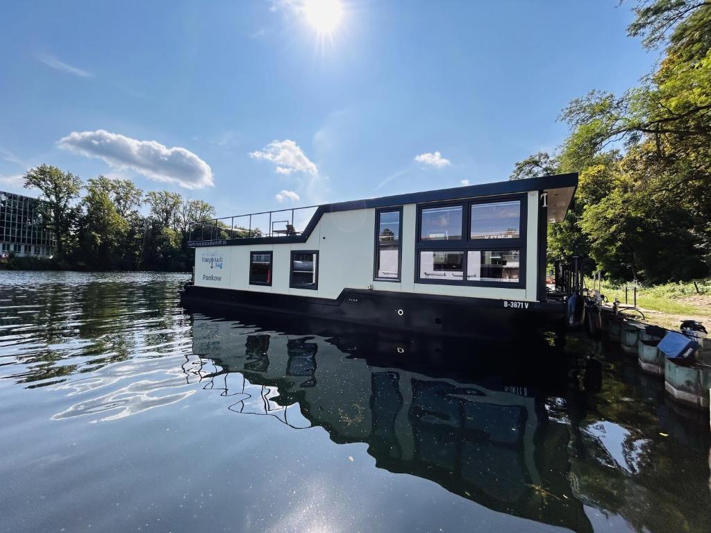 ein Haus auf einem Boot auf einem Fluss in der Unterkunft Hausboot Charlottenburg in Zeuthen