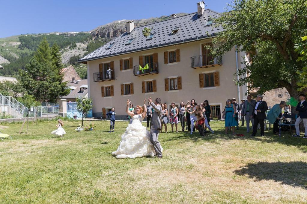 une mariée et un marié dansant devant un groupe de personnes dans l'établissement Appartement Etendard au Clos Marie, au Monêtier-les-Bains