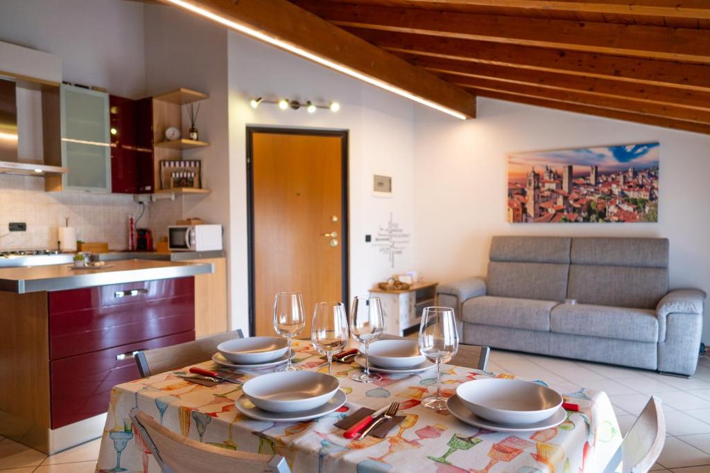 una mesa con vasos y platos en ella en una cocina en Incantevole Mansardato 75mq vicino a BGY, en Zanica
