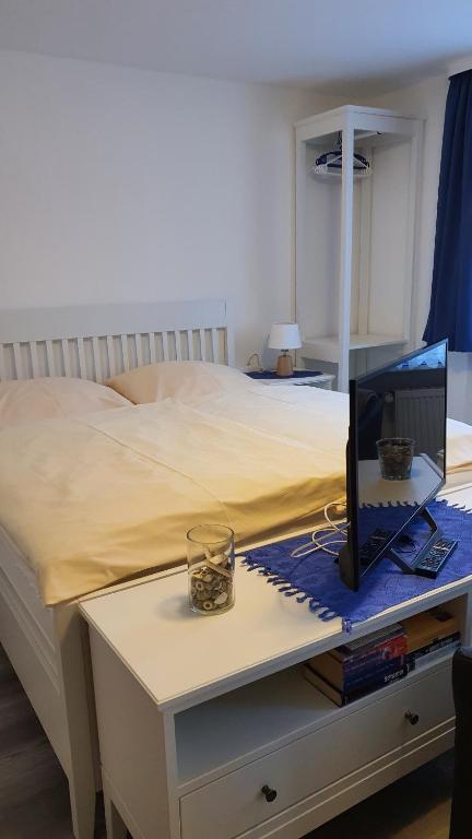 a bedroom with a bed and a desk with a computer on it at Appartementhaus Eiergrogstube in Helgoland