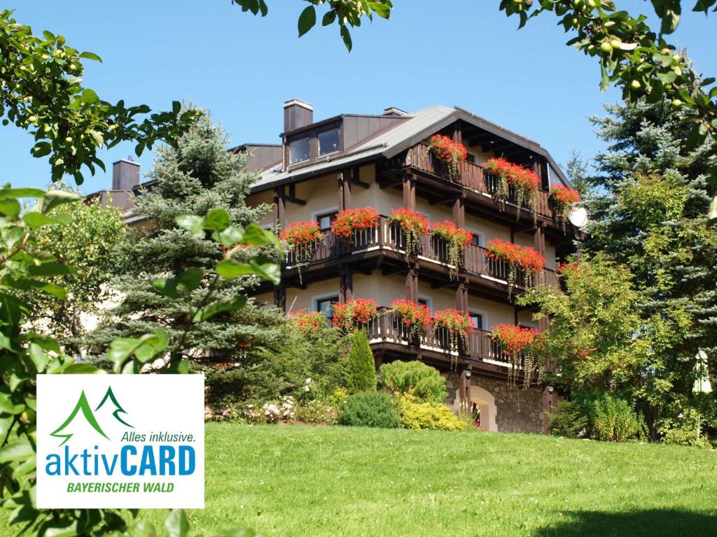 ein Apartmenthaus mit Blumen auf den Balkonen in der Unterkunft Falkenhof classic in Bayerisch Eisenstein