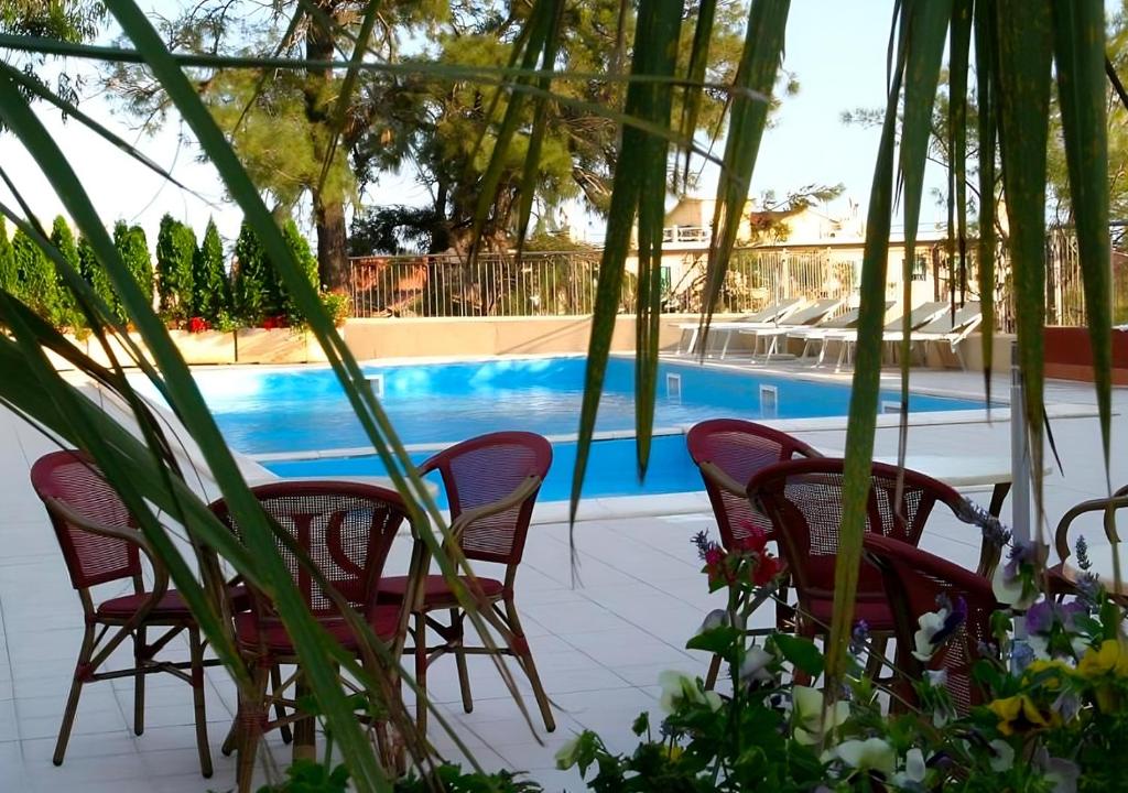 um grupo de cadeiras sentadas ao lado de uma piscina em Hotel San Giuseppe em Finale Ligure