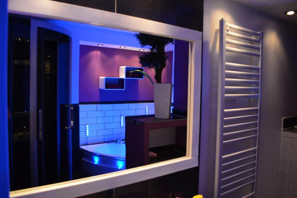ein Badezimmer mit einer Badewanne mit lila Beleuchtung in der Unterkunft SinueSsa in Köln