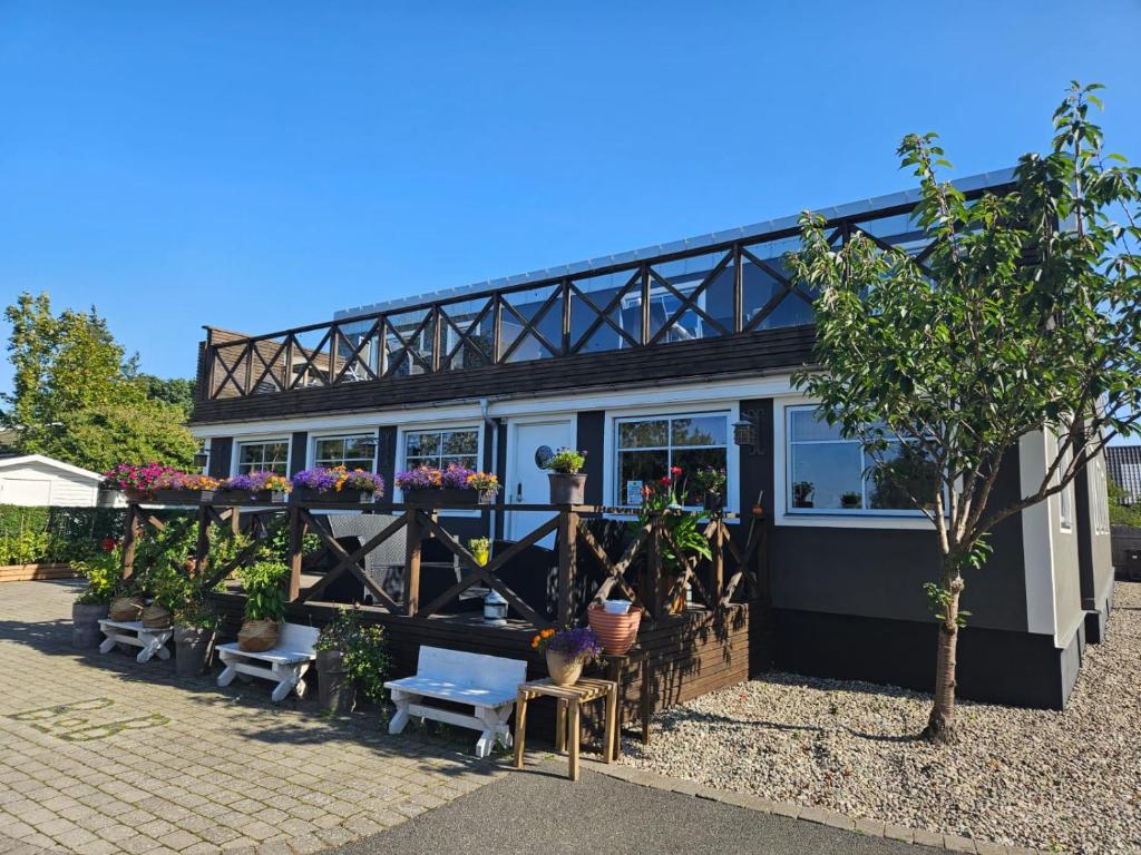 a black and white building with potted plants at Kaptenshuset Hotell in Kivik