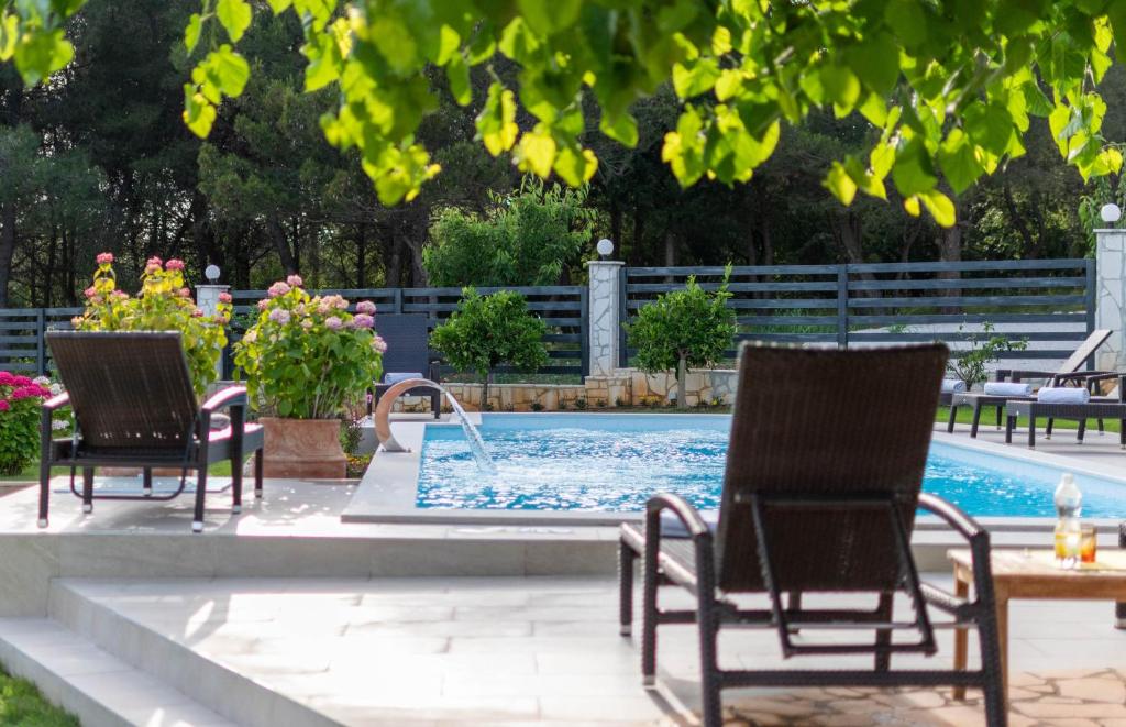 波雷奇的住宿－Stancia Rosa - Apartment sea view，一个带两把椅子和一张桌子的游泳池