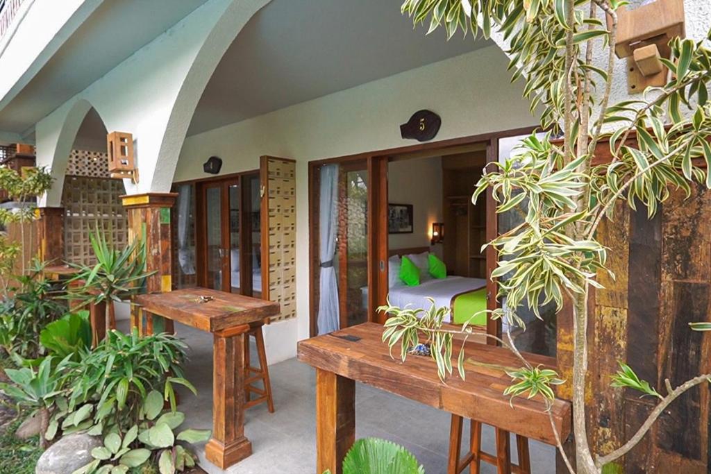una camera con panchina e letto in una stanza di Rumah Bali Hijau a Munggu